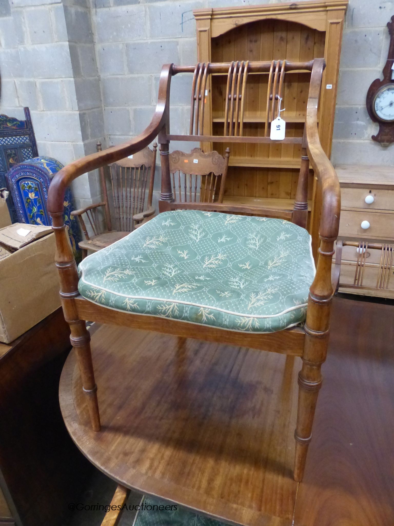 A reproduction mahogany twin pillar extending dining table and a set of six Regency fruitwood caned seated elbow chairs